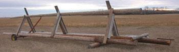 Slanted wall design using salvaged power poles with permanent back axle